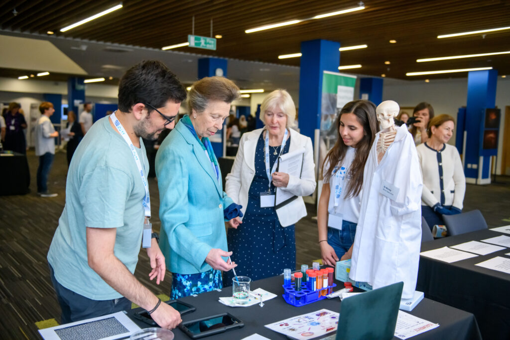 HRH The Princess Royal taking part in a hands-on exhibit with a pipette