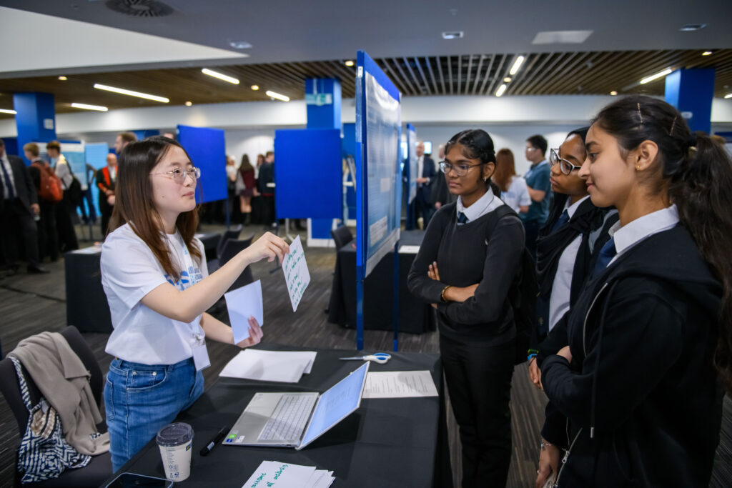 Pupils and a reseaecher looking at flash cards being used to discuss a research project.